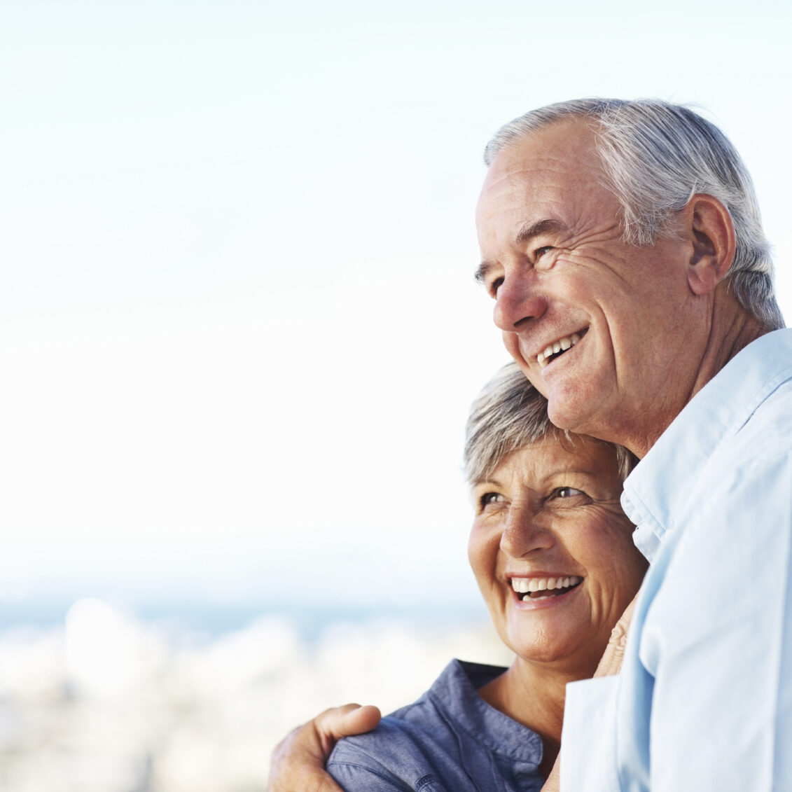 Closeup of handsome mature man and woman smiling while embracing outdoors